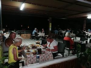 a group of people sitting at a table eating food at Hotel Grün in Kızılot