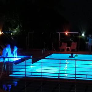 a swimming pool at night with blue lights at Hotel Grün in Kızılot