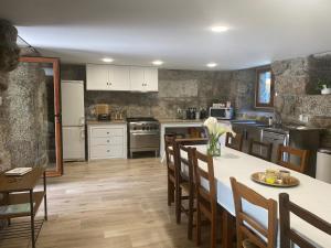 a kitchen with a table and chairs and a counter top at Quinta dos Mouras in Celorico de Basto