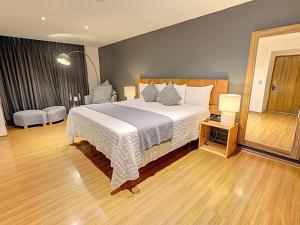 Hotel CLARUM 101 في غواذالاخارا: غرفة نوم بسرير كبير وارضية خشبية