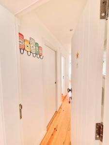 a hallway with white walls and a hard wood floor at Apartamentos Aurea in Sesimbra