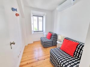 a living room with two chairs and a window at Apartamentos Aurea - Sesimbra in Sesimbra
