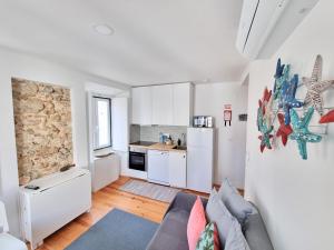 a living room with a couch and a kitchen at Apartamentos Aurea in Sesimbra