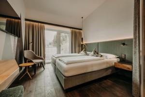 A bed or beds in a room at Hotel VIEW - incl Joker Card in Summer