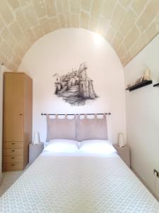 マテーラにあるNei Sassi da Ninoのベッドルーム1室(壁に絵画付)