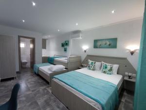 a hotel room with two beds and a bathroom at De plata apartments in Sarti
