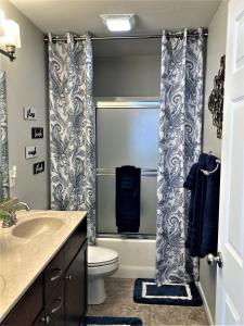 a bathroom with a toilet and a sink and a shower at Peaceful 1st floor lakeside condo minutes from Osage Beach and Ozark State Park in Kaiser