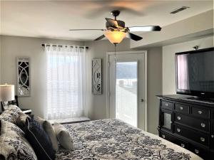a bedroom with a bed and a ceiling fan at Peaceful 1st floor lakeside condo minutes from Osage Beach and Ozark State Park in Kaiser
