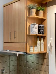 a kitchen with wooden cabinets with bottles and plants at Nemeapolis 2 apt in Neméa