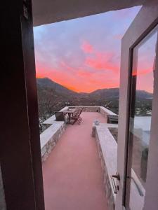 uma vista para o pôr-do-sol a partir da varanda de uma casa em villa Elpiniki Tilos em Megálon Choríon