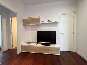 Apartamento en el centro de Llanes في يانس: غرفة معيشة مع تلفزيون بشاشة مسطحة على خزانة
