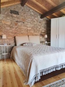 a bedroom with a bed and a stone wall at Casa da Portela in Caminha