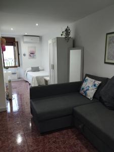 a living room with a couch and a bed at Roman Circus views Apartment in Tarragona