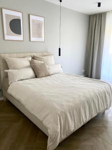 een bed met witte lakens en kussens in een slaapkamer bij DOCK 12 - Exklusives Cityapartment in Bremerhaven