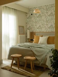 アグリニオにあるAgrinio ART Suitesのベッドルーム1室(ベッド1台、隣にスツール2つ付)