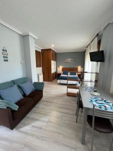 a living room with a couch and a bedroom at Apartamentos Rurales & Spa Antilles Playa in Llanes