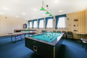 a pool table in a room with tables and chairs at Nalu Glamp in Darłowo