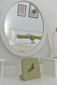 espejo reflejo de una cama en un dormitorio en Olivo luxury apartment, en Hydra