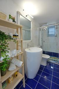 a bathroom with a tub and a shower and a toilet at Olivo luxury apartment in Hydra