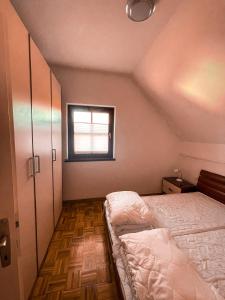 niewielka sypialnia z łóżkiem i oknem w obiekcie Mad House Apartment 1, Terme Čatež w mieście Čatež ob Savi