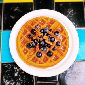 a plate of waffles with blueberries and nuts on it at Hibiscus Coffee & Guesthouse in Santa Rosa Beach