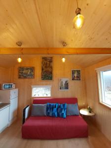 a living room with a red couch in a tiny house at Cosy Cottage in Golden Circle near Thingvellir in Vaðlækir