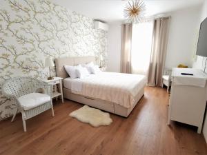 a white bedroom with a bed and a desk and a chair at Duplex Maria Di, Free Parking, Sea View in Dubrovnik