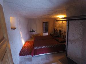 a bedroom with a bed in a stone room at CAPPADOCİA ST.NİNO'S GARDEN in Ortahisar