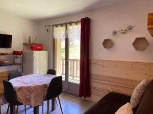 uma sala de jantar com uma mesa e uma janela em Appartement rez de jardin expo sud em Saint-Gervais-les-Bains