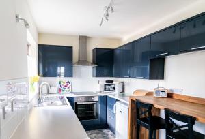 a kitchen with black cabinets and a wooden counter top at Chestnut Cottage at Gravel Farm in Stretham