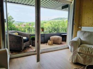 a living room with a sliding glass door to a balcony at Chalet in Ühlingen-Birkendorf