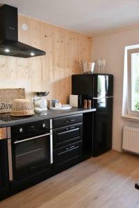 a kitchen with black appliances and a black refrigerator at Chalet in Ühlingen-Birkendorf