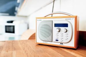 una pequeña radio sentada sobre una mesa de madera en Chestnut Cottage at Gravel Farm, en Stretham