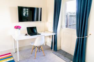 a desk with a laptop on it next to a window at Elm Cottage at Gravel Farm in Stretham