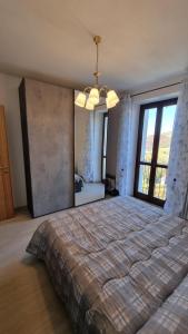 a bedroom with a large bed and a large window at Ca ed Giuanoto in Santo Stefano Belbo