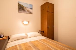 a bedroom with a bed with a light on the wall at Apartment Mario with Terrace and Sea View in Baška