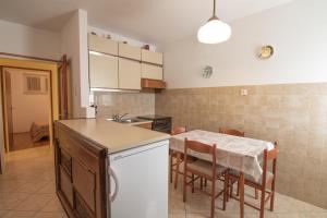 a kitchen with a table with chairs and a counter top at Apartment Mario with Terrace and Sea View in Baška