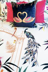 a bed with two flamingos pillows on it at Chestnut Cottage at Gravel Farm in Stretham