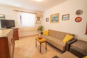 a living room with a couch and a tv at Apartment Mario with Terrace and Sea View in Baška