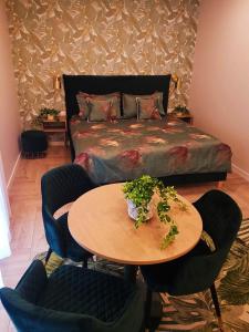 - une chambre avec un lit, une table et des chaises dans l'établissement Apartamentų Nuoma MiniLiux, à Palanga