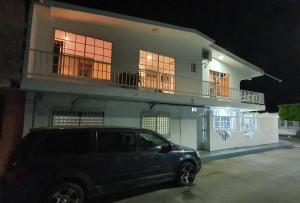 Un todoterreno estacionado frente a una casa por la noche en Posada Turística Colors of the Sea, en San Andrés