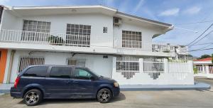 a blue van parked in front of a white house at Posada Turística Colors of the Sea in San Andrés