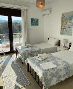 Cette chambre comprend 2 lits et une fenêtre. dans l'établissement NanSea Apartment, à Loutra Elenis
