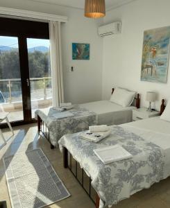 a hotel room with two beds and a window at NanSea Apartment in Loutra Oraias Elenis 