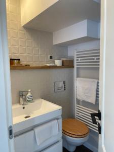 Un baño con un lavabo blanco y un inodoro. en Upon Boutique, en Sinaia