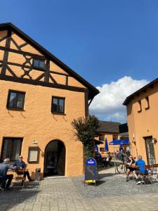 a group of people sitting at tables in front of a building at Der Limes Kipfenberg in Kipfenberg