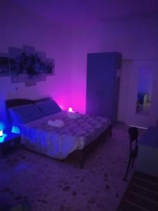 Habitación oscura con cama y luz rosa en All inBasilicata Bed & Breakfast, en Baragiano