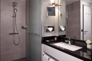 a bathroom with a sink and a shower at INNSiDE by Meliá Wolfsburg in Wolfsburg