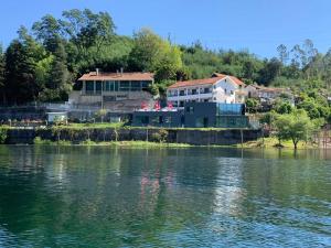 a house on the shore of a lake with a house at Beira Rio do Gerês in Geres