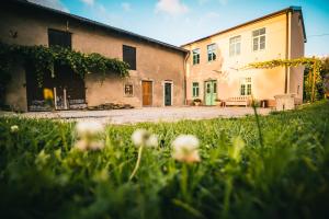 ein Gebäude mit einem Hof mit Blumen im Gras in der Unterkunft BELAKAPA Authentic house with garden and free parking in Ilirska Bistrica